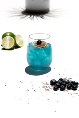Blue cocktail with lime and blueberry garnish, beverage photography Dallas, Texas