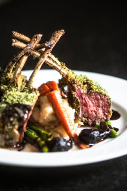 Herb-crusted rack of lamb with mashed potatoes and red wine reduction, food photography Dallas, Texas