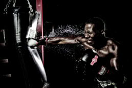 Boxer punching heavy bag with Ringside gloves, commercial portrait photography Dallas, Texas