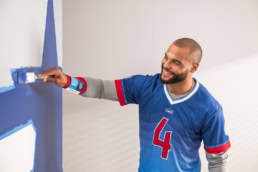 Dak Prescott painting a wall for Lowe's DIY Home Improvement campaign, commercial photography Dallas, Texas