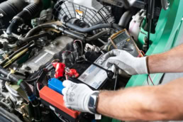 Technician testing forklift battery with multimeter, Equipment Depot industrial photography Dallas, Texas
