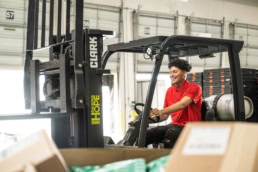 Equipment Depot worker operating Clark forklift in warehouse, commercial photography Dallas, Texas