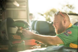 Indy Lights racing driver preparing Stilo helmet in pit area, motorsport photography Dallas, Texas