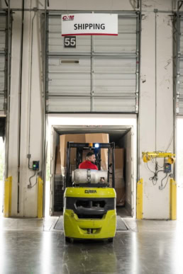 Clark forklift operator at OSM Worldwide shipping dock 55, industrial photography Dallas, Texas