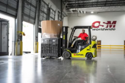OSM Worldwide warehouse worker operating Clark forklift, industrial photography Dallas, Texas