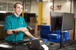 OSM Worldwide warehouse employee scanning packages, commercial photography Dallas, Texas