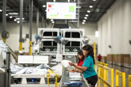 OSM Worldwide warehouse workers sorting packages on conveyor belt, industrial photography Dallas, Texas