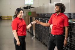 OSM Worldwide warehouse team members fist bumping, commercial photography Dallas, Texas