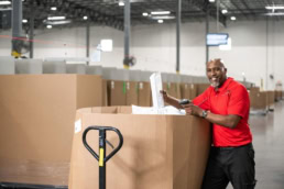 OSM Worldwide warehouse worker scanning packages, industrial photography Dallas, Texas