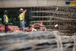 TAS Concrete construction workers directing rebar installation, industrial photography Houston, Texas