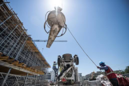 TAS Concrete crane lifting concrete bucket at construction site, industrial photography Houston, Texas
