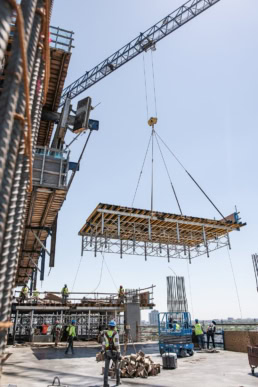 TAS Concrete construction crew with crane lifting formwork table, industrial photography Houston, Texas