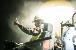TAS Concrete worker operating paving machine at night, industrial photography Houston, Texas