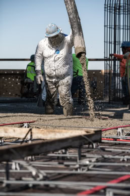 TAS Concrete worker pouring concrete on commercial job site, industrial photography Houston, Texas