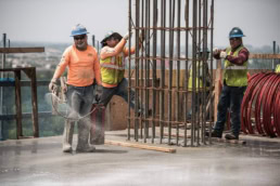 TAS Concrete workers tying rebar column on elevated slab, industrial photography Houston, Texas