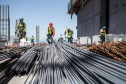 TAS Concrete construction workers handling rebar bundles on jobsite, industrial photography Houston, Texas
