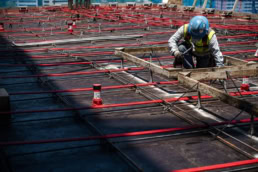 TAS Concrete worker tying rebar on formwork, industrial construction photography Houston, Texas