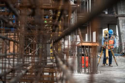 TAS Concrete surveyor using Topcon total station on construction site, industrial photography Houston, Texas