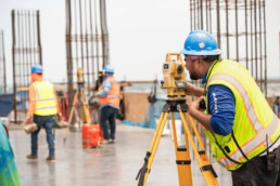 TAS Concrete surveyor using Topcon total station on construction site, industrial photography Houston, Texas