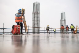 TAS Concrete surveyor using Topcon total station on high-rise concrete slab, industrial photography Houston, Texas
