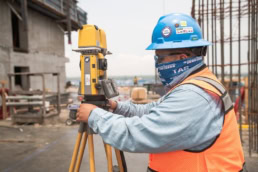 TAS Concrete surveyor using Topcon total station on construction site, industrial photography Houston, Texas