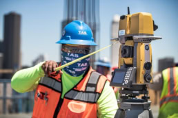 TAS Concrete surveyor using Topcon total station on construction site, industrial photography Houston, Texas