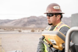 Topcon construction worker operating equipment in desert landscape, industrial photography Fort Worth, Texas