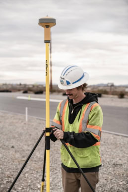 Topcon GPS surveying equipment operator in hi-vis vest, industrial photography Fort Worth, Texas