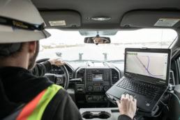 Topcon worker using laptop with mapping software in Ford truck, industrial photography Fort Worth, Texas