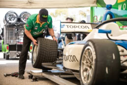 Topcon Indy Lights crew member handling tire in pit area, motorsport photography Fort Worth, Texas