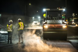 Topcon asphalt roller and construction crew working at night, industrial photography Fort Worth, Texas