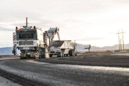 Topcon road milling machine loading asphalt into dump truck, industrial photography Fort Worth, Texas