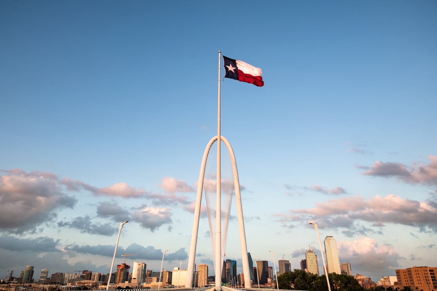 Margaret Hunt Hill Bridge with Texas flag and Dallas skyline, commercial photography Dallas, Texas