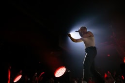 Dave Matthews singing on stage with dramatic backlighting, event photography Dallas, Texas