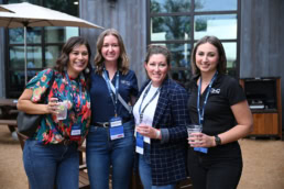 Four women networking at corporate event with BHC badges, event photography Dallas, Texas
