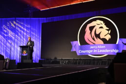 Jerry Allen Courage In Leadership corporate event speaker at podium, event photography Dallas, Texas