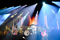 Imagen Dragons performing on stage with Gretsch drums and dramatic lighting, event photography Dallas, Texas