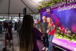 Couple posing at Wells Fargo Autograph Card Exclusives photo backdrop, event photography Dallas, Texas
