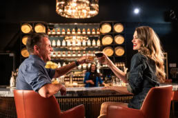 Couple toasting cocktails at Blackland Distillery bar, commercial photography Fort Worth, Texas