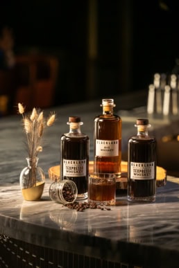 Blackland Distillery Texpresso and Rye Whiskey bottles with coffee beans, commercial photography Dallas, Texas