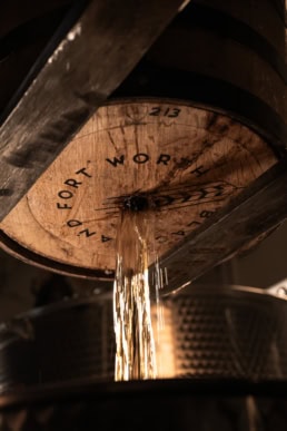 Blackland Distillery whiskey barrel 213 pouring aged spirit, commercial photography Dallas, Texas