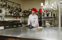 Dallas College culinary student kneading dough in commercial kitchen, ad campaign photography Dallas, Texas