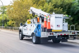 Spectrum bucket truck with cable reels and safety cones, commercial photography Dallas, Texas