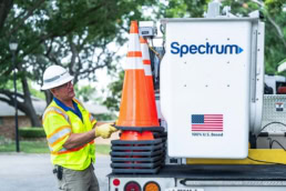 Spectrum field technician loading traffic cones onto service truck, commercial photography Dallas, Texas