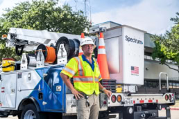 Spectrum field technician standing by service truck, industrial photography Dallas, Texas