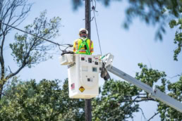 Spectrum technician in bucket truck working on utility pole, industrial photography Fort Worth, TX