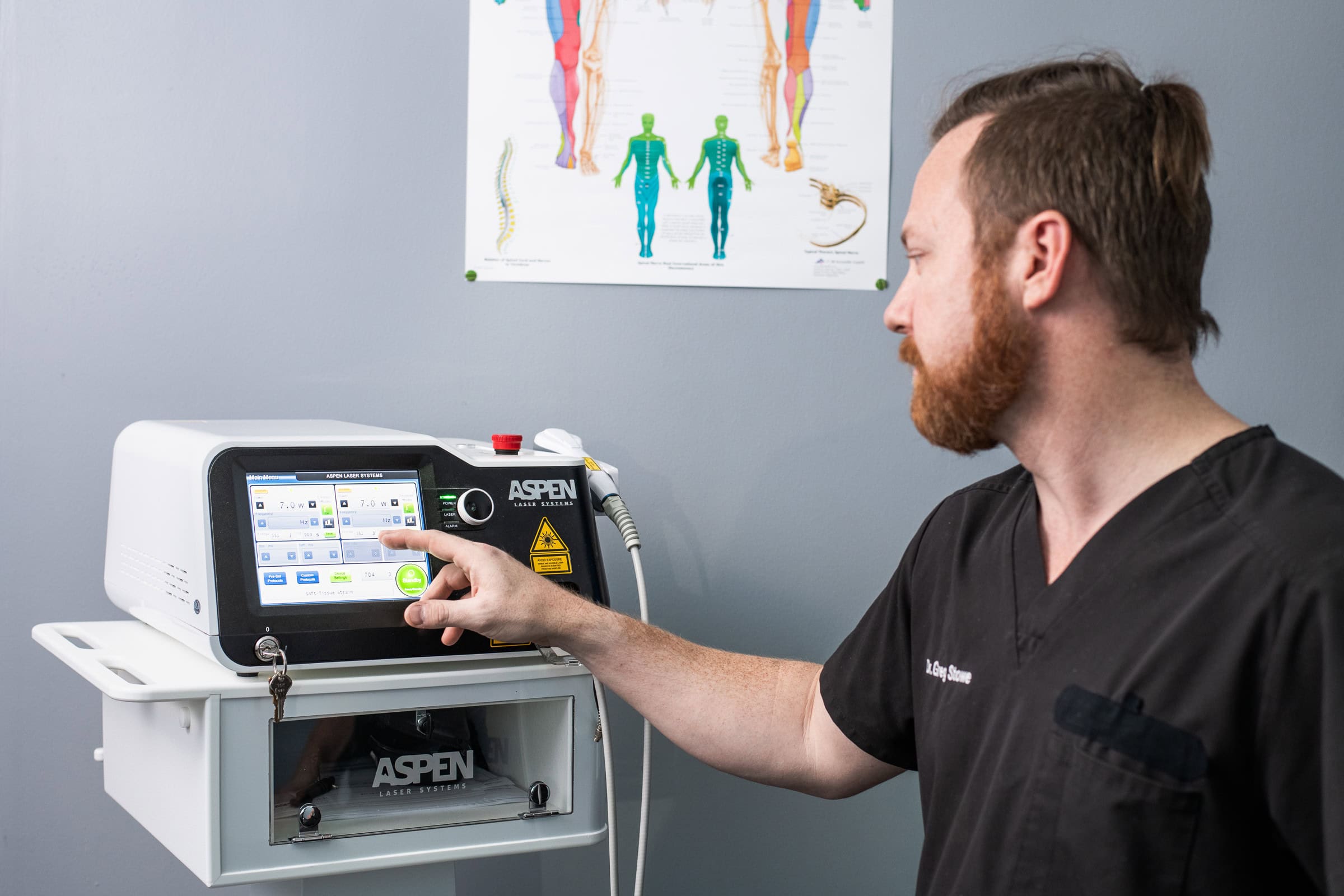 Clinician operating an Aspen Laser Systems device on a patient, medical device and technology photography in Dallas, Texas by David Loi Studios