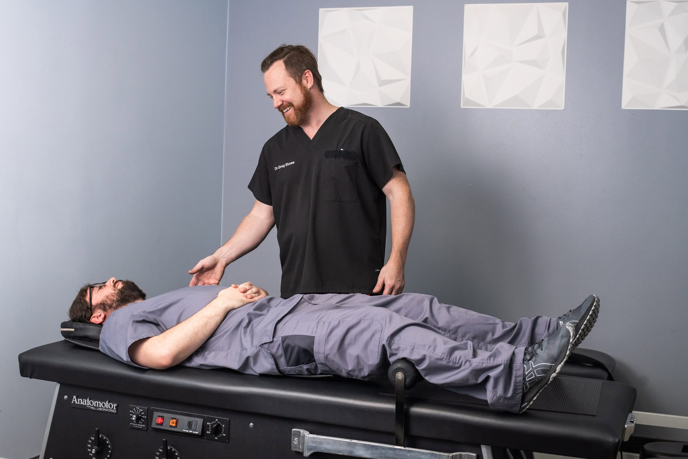 Chiropractor treating patient on Anatomotor table, commercial portrait photography Dallas, Texas