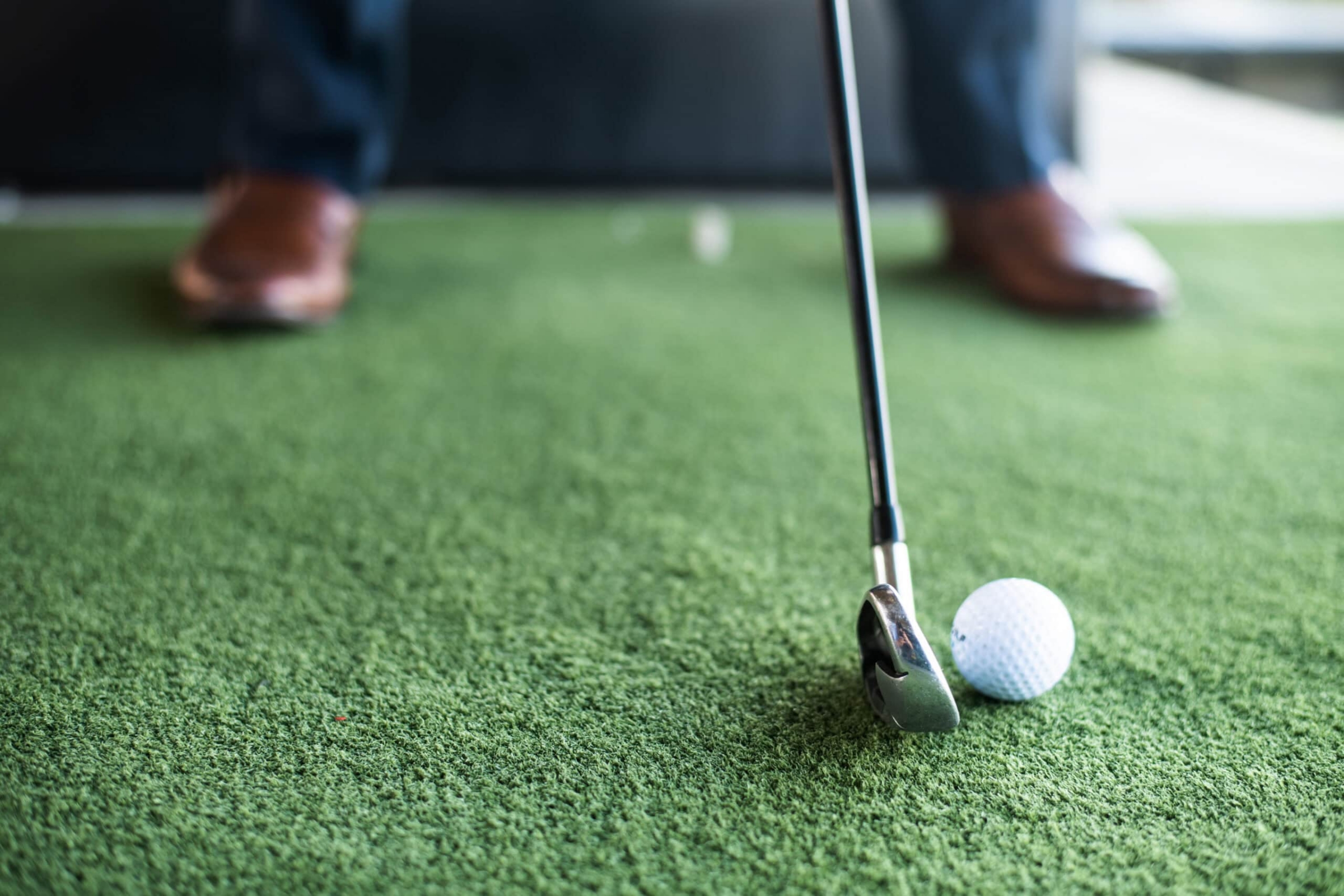 Indoor putting green with golf club and ball, commercial event photography Dallas, Texas