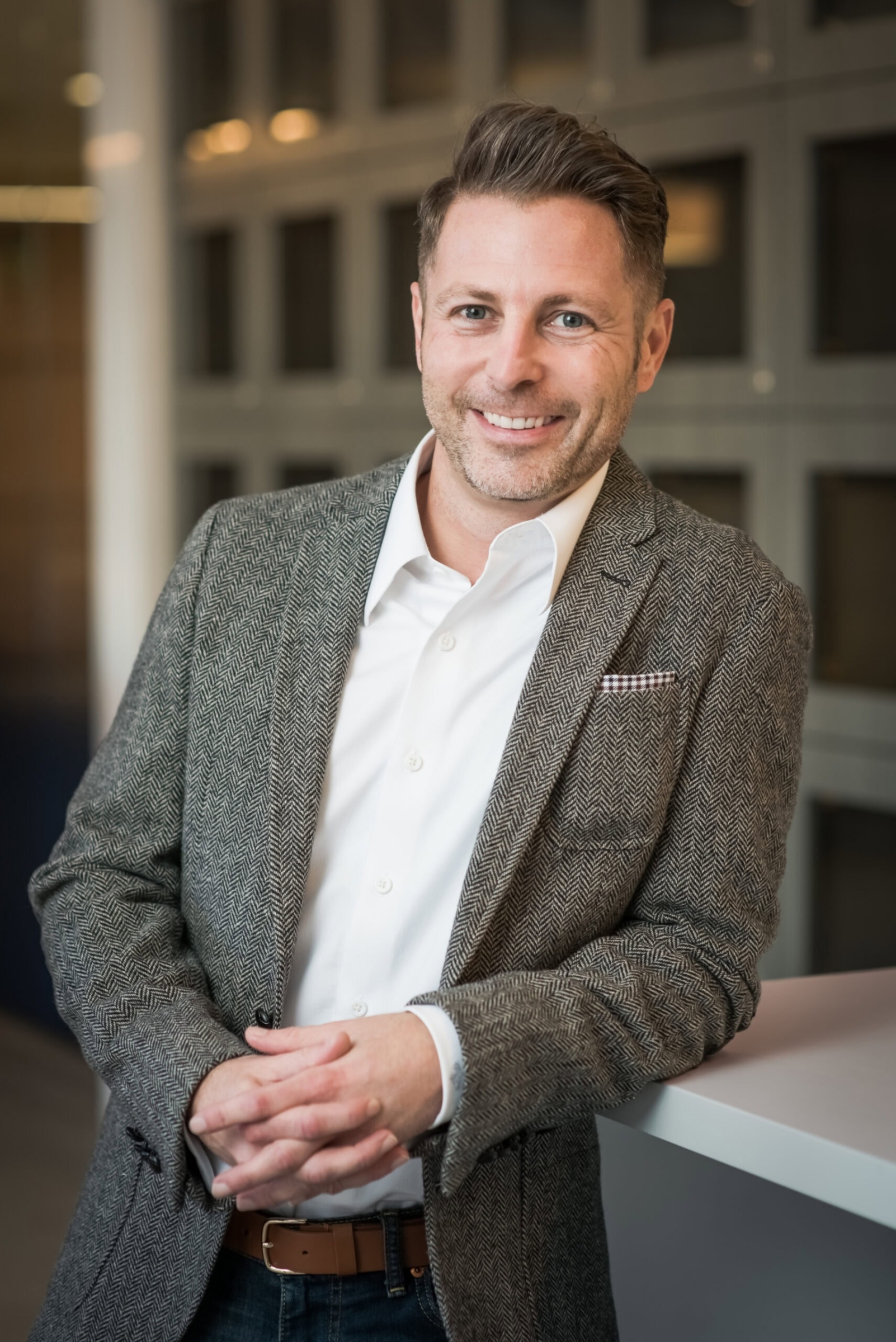 Corporate headshot of a man in a herringbone blazer, headshot photography in Addison, Texas by David Loi Studios